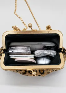 Detail showing the internal storage space of the leopard print plush shell bag with chain