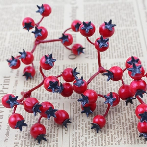Artificial red Christmas berry branches on vintage newspaper background for home DIY decor