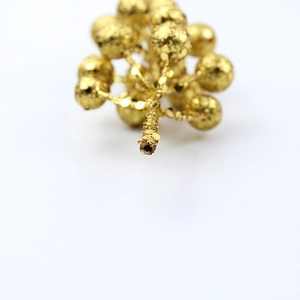 Macro detail of golden glitter berry pick with metallic finish for Christmas decorations