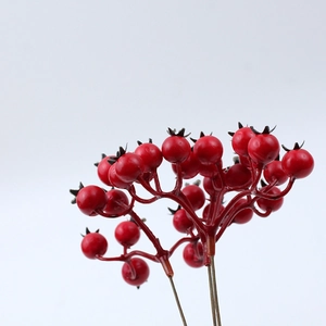 Close-up of red artificial Christmas berries with detailed brown stems for DIY decor