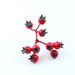 Close-up of artificial Christmas red berries with nine pomegranate fruit heads on stems