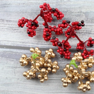 Close-up of artificial red and gold foam berries on stems for Christmas DIY decor