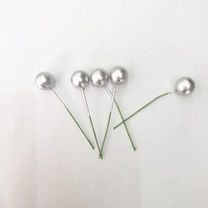 Macro view of five silver artificial foam berry stems with green wire for DIY Christmas wreaths