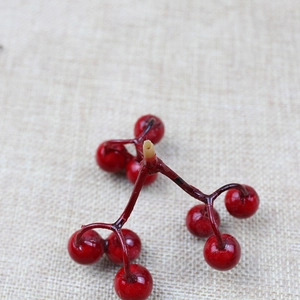 Close-up of vibrant red artificial Christmas berries on branch for festive decoration