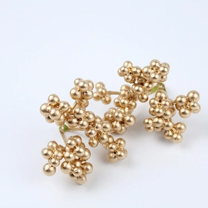 Macro shot of 5cm gold frosted berry clusters for festive Christmas tree decor