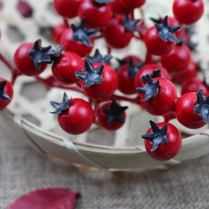 Detail of red Christmas berries with black star calyx in a woven basket with burlap back