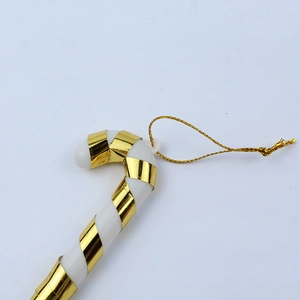 Nahaufnahme von Zuckerstangen-Weihnachtsschmuck mit goldenem Band auf blauem Hintergrund