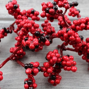 Macro shot of artificial red and black berries on branches for Christmas decor