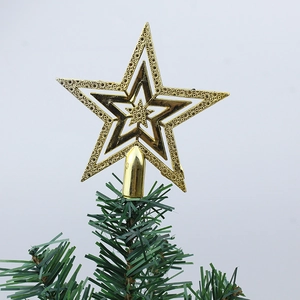 Close-up of golden 5-point Christmas tree star topper with intricate cutout patterns
