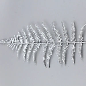 Detailed view of a silver glitter feather leaf decoration with a metallic finish