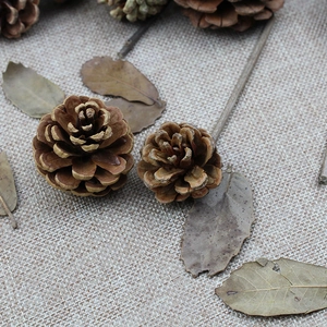 Close-up of natural dried brown pine cones on rustic linen fabric for Christmas decor