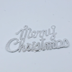 Detail of silver Merry Christmas hanging sign with textured dot relief and double loops