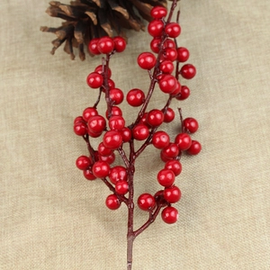 Close-up of glossy red simulation berries on brown stems for Christmas decor