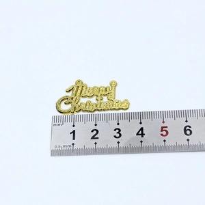 Close-up of golden Merry Christmas tag with textured finish and measurement scale