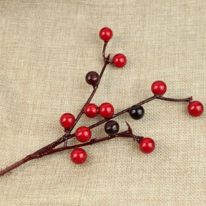 Detailed view of artificial red berry branches on a beige textured linen background