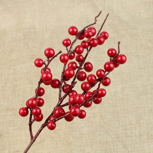 Detailed view of glossy red Christmas berry stems on a rustic beige linen background