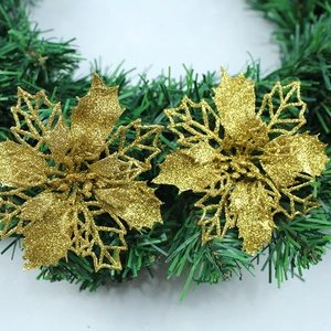 Close-up of golden glitter hollow Christmas flower ornaments on pine branches