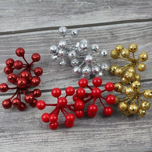 Close-up of glittery and glossy Christmas berry clusters on a gray wood background