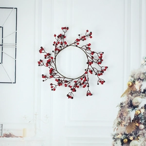 Red berry Christmas wreath hanging on a white wall in a cozy holiday home setting