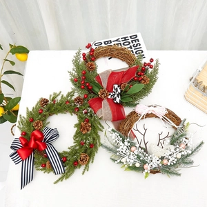 Detailed view of three festive Christmas wreaths with pine needles, berries and pine cones