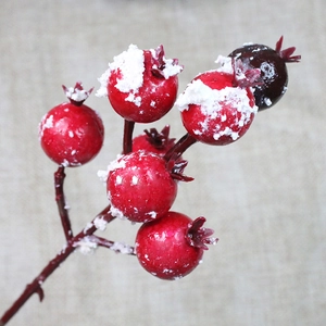 Close-up of artificial red holly berries with frosted snow detail for Christmas decor