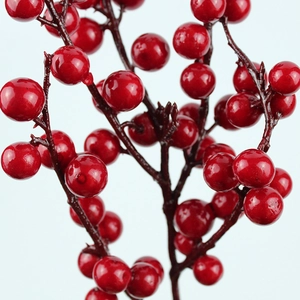 Close-up of glossy red artificial berries and lifelike dark brown branches for decor