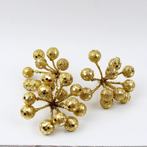 Macro view of Christmas glitter berry branches with sparkling gold powder and sequins