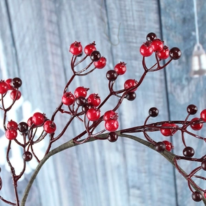 Macro shot of realistic red and purple Christmas berry wreath on blue wood background