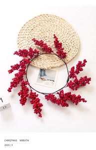 Close-up of a festive red berry Christmas wreath on a natural woven table mat