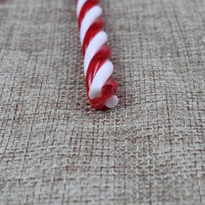 Nahaufnahme von rot-weißen Spiral-Zuckerstangenstäben auf rustikalem Sackleinenstoff