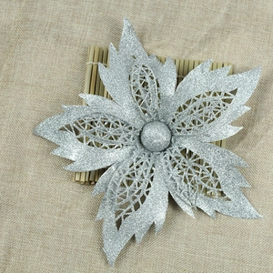 Close-up of silver glitter Christmas flower with hollowed mesh petals on burlap