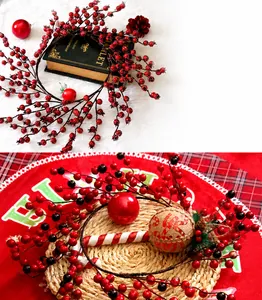 Detailansicht der roten und dunkellila künstlichen Stechpalmenbeeren am Weihnachtskranz