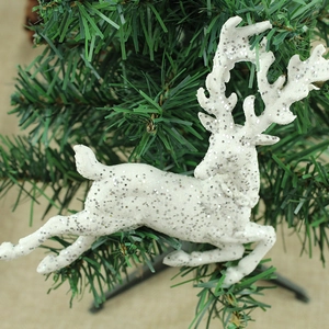 Ornamento natalizio a forma di renna bianca scintillante appeso a un ramo dell'albero