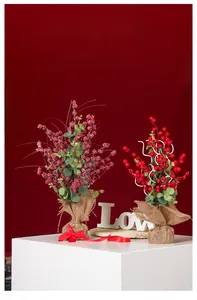 Dettaglio di agrifoglio con bacche rosse, base in iuta e accenti di neve festiva