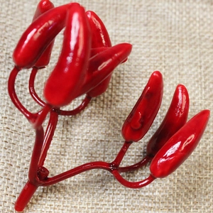 Close-up of bright red artificial mini chili peppers on a rustic burlap background