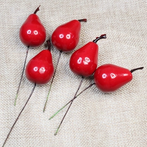 Five bright red artificial decorative berries with brown wire stems on burlap backdrop