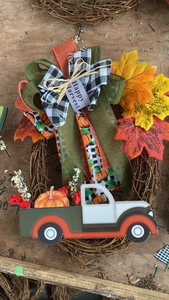 Gros plan d'une couronne d'automne avec camion vintage, feuilles d'érable et nœud décoratif