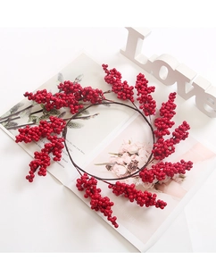 Detail of red faux berry Christmas wreath on an open magazine with white love sign