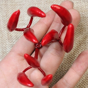 Macro detail of glossy red artificial mini pepper decor on rustic burlap background