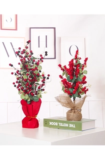 Dettaglio di bonsai con bacche rosse finte in confezione regalo di carta e iuta