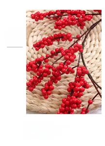 Close-up of artificial red Christmas berries with natural gloss on a woven placemat
