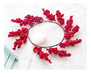 Close-up of artificial red berry Christmas wreath on a soft white plush background