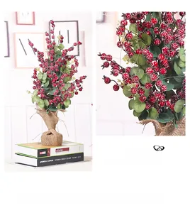 Dettaglio di bacche rosse invernali con neve artificiale e base in juta decorativa