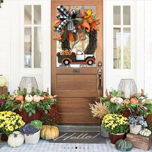 Couronne d'automne avec camion de citrouilles et feuilles d'érable sur une porte