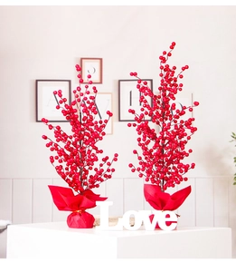 Detail of red artificial holly berry trees with festive gold wire base for home decor
