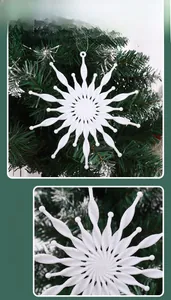 Detail of white 3D snowflake ornament with glitter finish hanging on a green Christmas tree