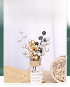 Close-up of metallic gold, silver and navy blue decorative Christmas berries in a vase
