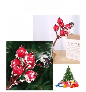 Détail de branches de baies de Noël rouges avec neige artificielle pour décoration