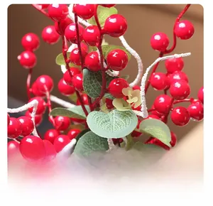Dettaglio di bacche di agrifoglio rosse con foglie verdi per decoro festivo
