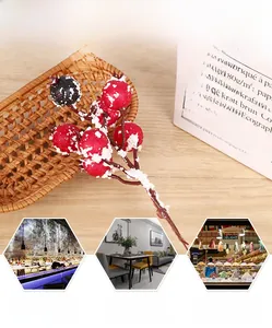 Détail de baies artificielles rouges et noires enneigées pour décoration de fête